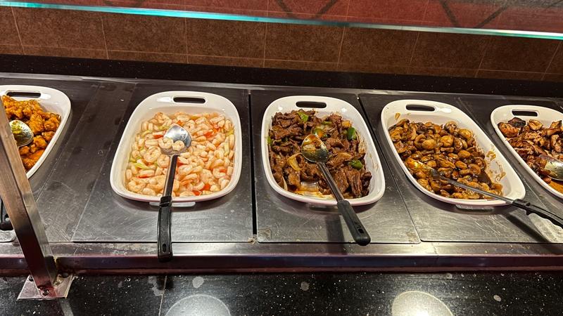 Hot bar with shrimp, beef, and mushroom dishes